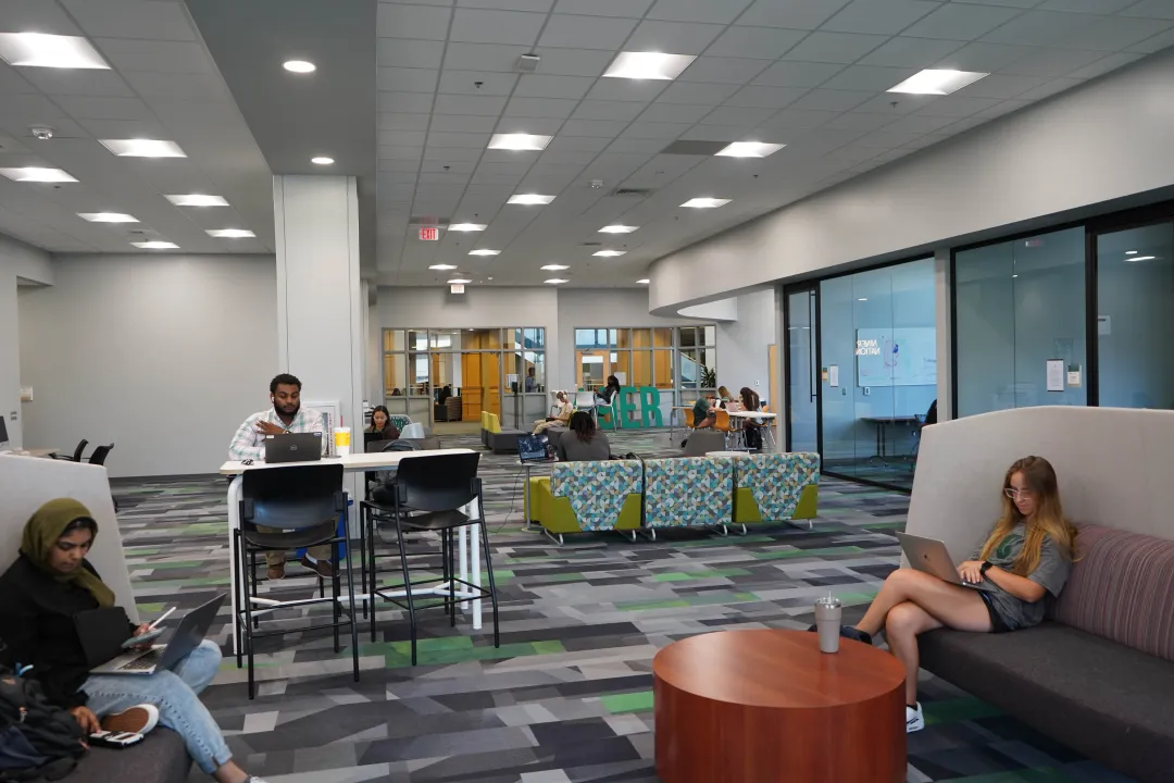 The Center for Student Involvement interior with couches, tables and students working at the tables